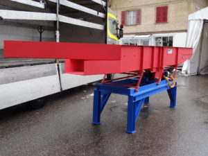 MATEC-Vibro-Mesh Vibrosieb MATEC Antrieb 3, Länge mit Aufgabezone 5700 mm, Breite 800 mm, Troghöhe 500 mm mit Siebboden für Kompostaussiebung. Die Ueberlängen gehen seitlich weg, das Gutmaterial geht geradeaus zur nächsten Förderanlage